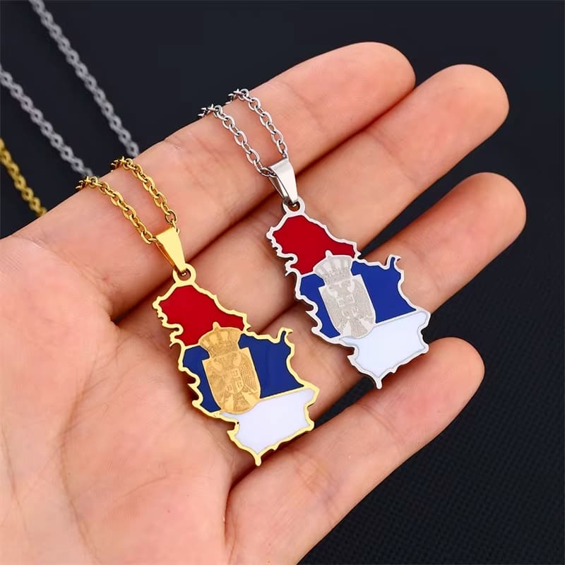 Pendentifs drapeau de Serbie en or et en argent dans une main