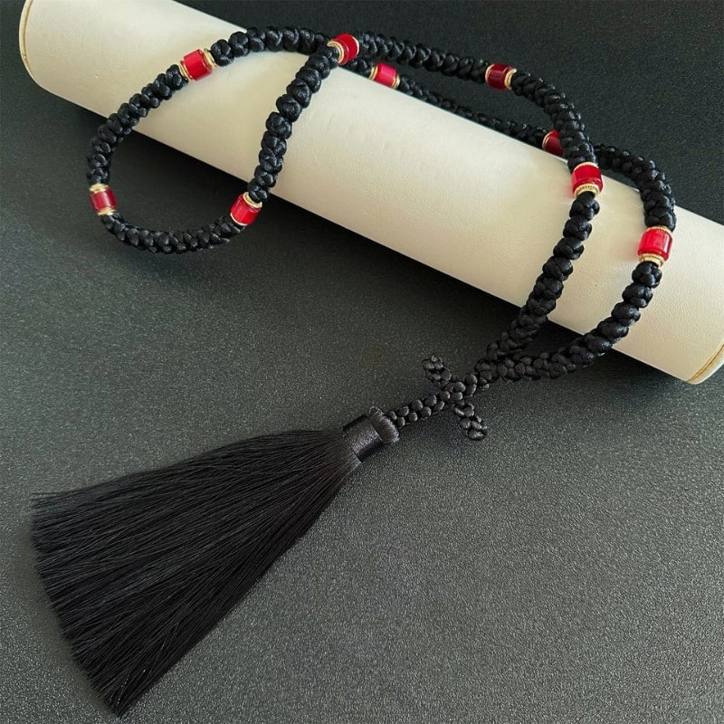 Tchotki orthodoxe noir fabriqué à la main posé sur un parchemin religieux