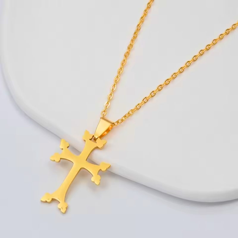 Croix florale arménienne en or présentée sur un fond clair