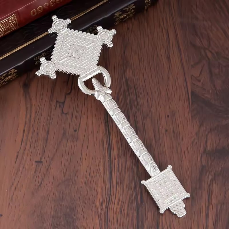 Croix à main éthiopienne en argent à côté de livres religieux éthiopiens