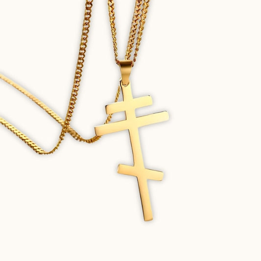 Collier croix orthodoxe en or pour homme posée sur fond clair