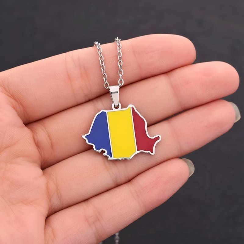 Pendentif de la carte et du drapeau de la Roumanie tenu dans une main
