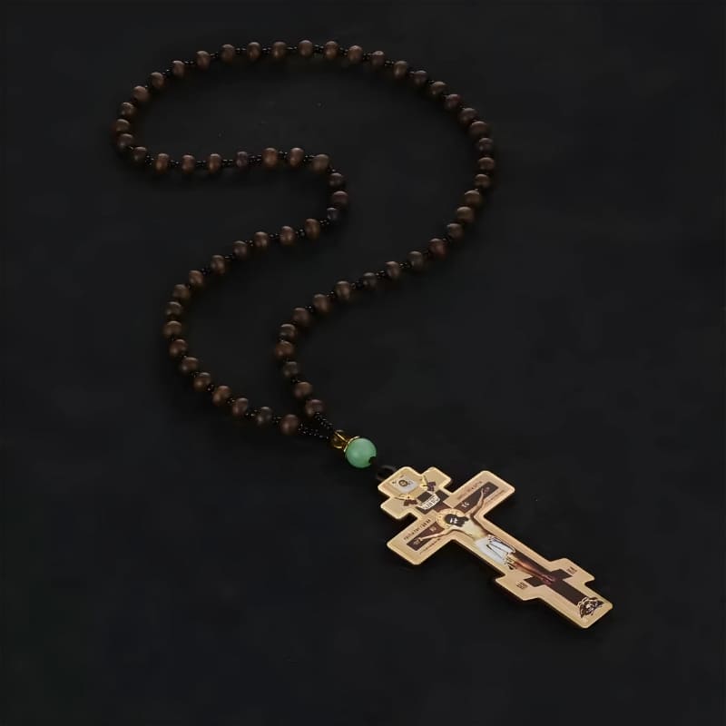Collier croix orthodoxe traditionnel en bois posé sur fond noir