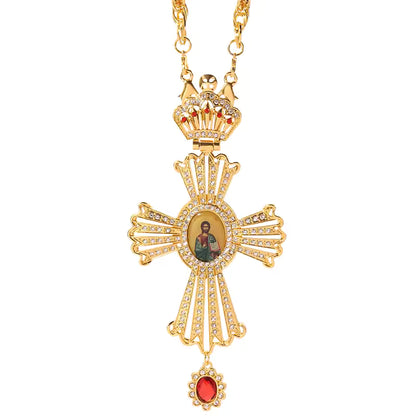 Collier pendentif croix byzantine dorée avec icône et pierre rouge, chaîne longue.