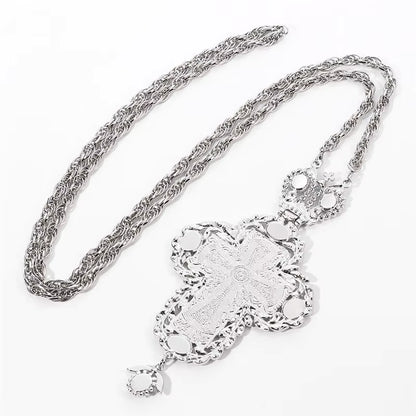 Collier avec pendentif croix argentée ornée de pierres turquoise et d'une longue chaîne.