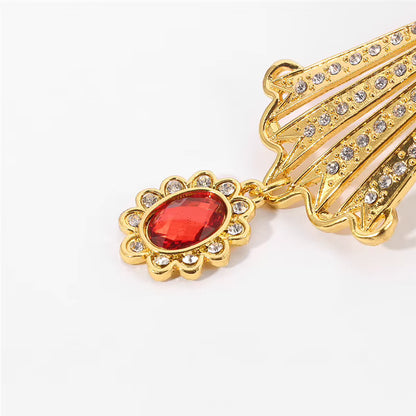 Pendentif de collier doré orné d'une croix pectorale byzantine avec une pierre rouge et des zircons.