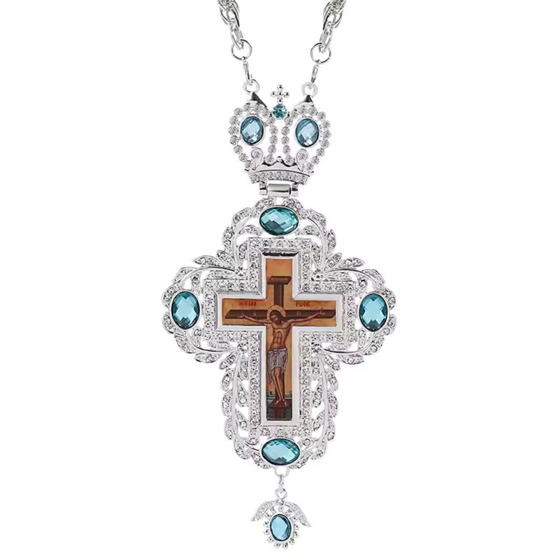 Collier pendentif croix pectorale argentée avec crucifix, pierres turquoise et chaîne longue.