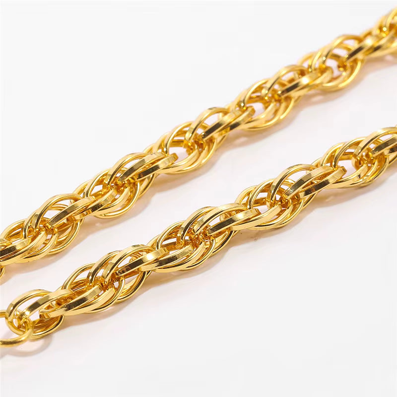Gros plan sur une chaîne de collier dorée style byzantin, maillons tressés.