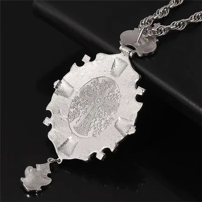 Dos d'un collier pendentif croix pectorale argentée ornées de motifs complexes.