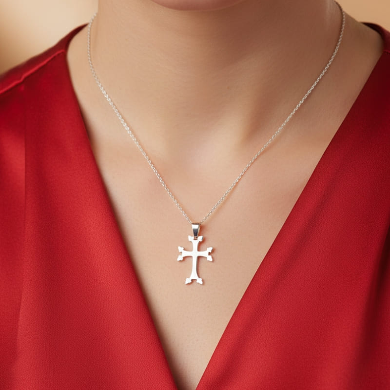 Pendentif croix arménienne en argent porté par une femme avec blouse rouge