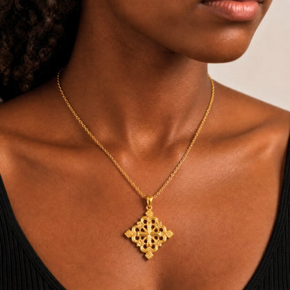 Pendentif croix éthiopienne en finition or porté par une femme noire 