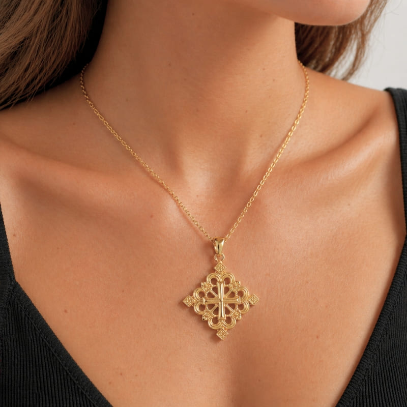 Collier en croix éthiopienne dorée portée par une femme dans un studio photo