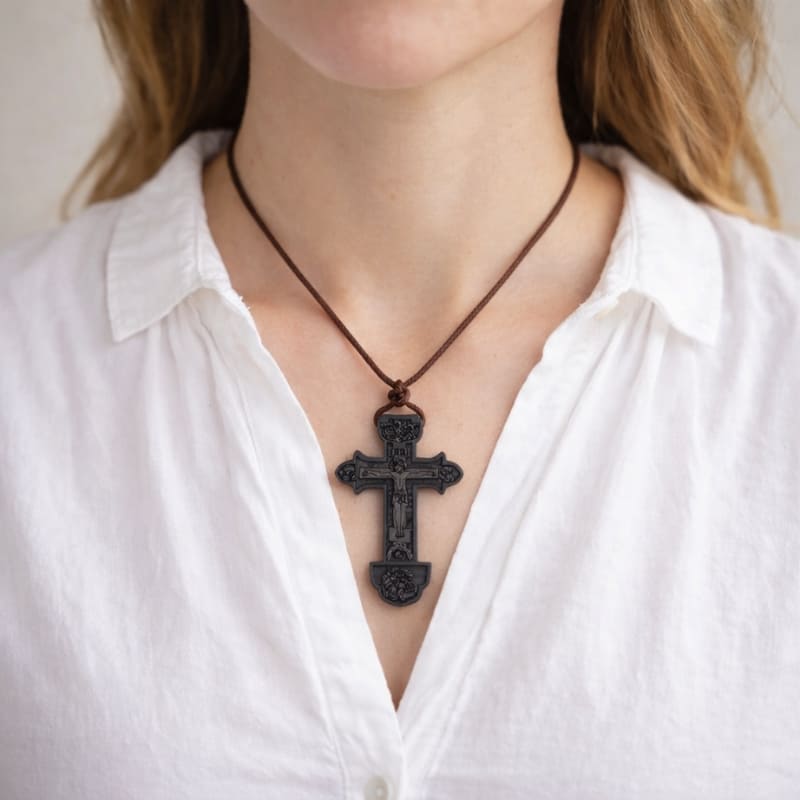 Collier croix orthodoxe en bois de couleur noir avec gravure de Jésus porté par une femme