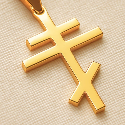 Gros plan sur un collier croix orthodoxe en acier inoxydable finition dorée