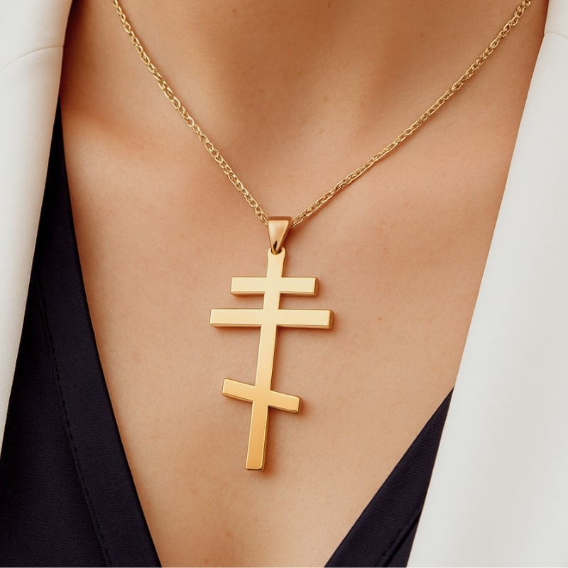 Collier croix orthodoxe avec finition dorée porté par une femme