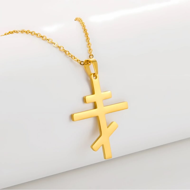 Pendentif croix orthodoxe dorée en acier inoxydable, vue produit sur fond neutre blanc